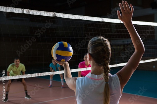 Obraz na plátně Rear view of volleyball player playing with teammates