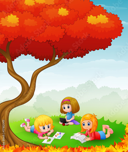 Fototapeta Naklejka Na Ścianę i Meble -  Happy children studying in the autumn trees
