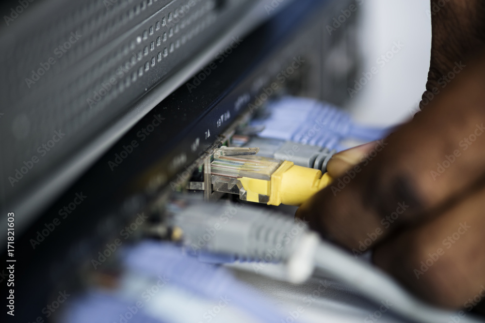 Hand holding a LAN cable to the hub Hand holding a LAN cable to the hub
