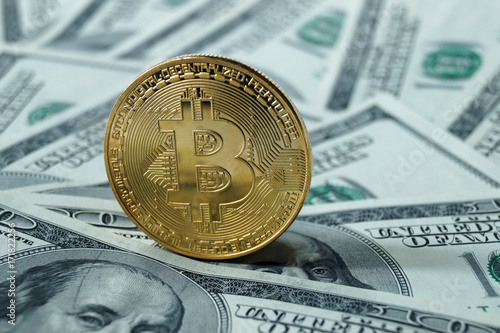 Obraz na płótnie A symbolic coins of bitcoin on banknotes of one hundred dollars. w salonie