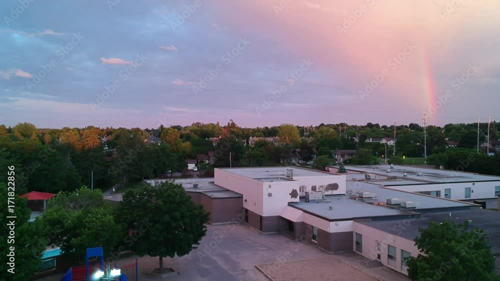 Crane/ Drone shot of a rainbow over a school and neighbourhood. Crane/ Drone shot of a rainbow over a school and neighbourhood.