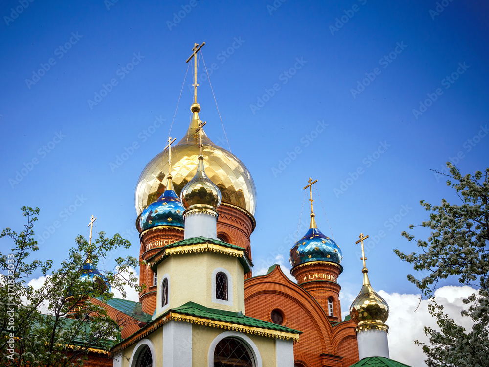 a Golden dome with a cross surrounded by spring flowers