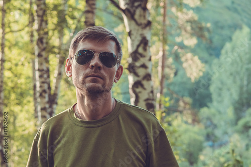 Young stylish man in summer forest in the mountains near Almaty city