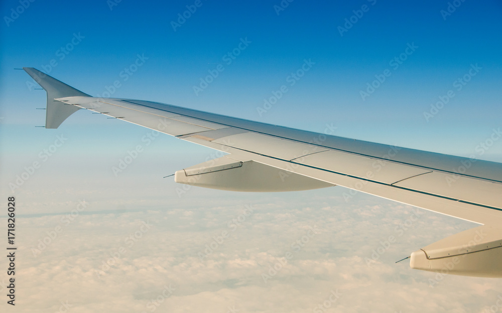 The wing of an airplane in the sky above the clouds. The wing of an airplane in the sky above the clouds.