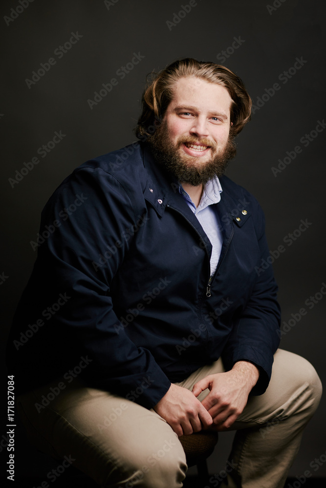man with beard and long hair smiling sitting