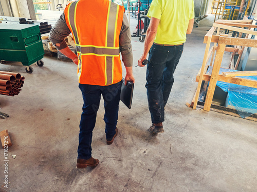men in construction outfits walking at site
