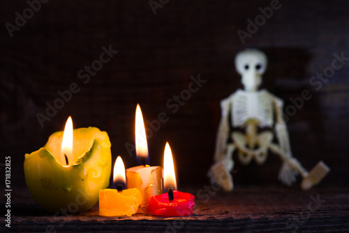 Halloween abstract background with skeleton and candles on cemetery  