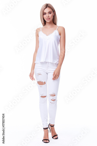 Pretty sexy lady beautiful woman clothes wear stylish white denim cotton jeans with holes skinny fit and silk blouse cute face makeup model pose catalog collection tan skin blond hair.