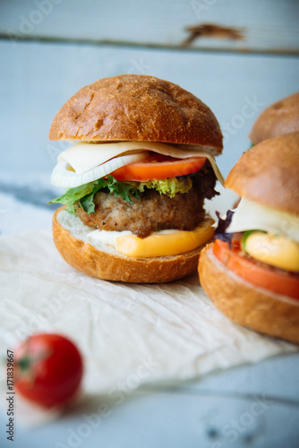 The traditional hamburger Patty, cheese, tomato, lettuce, beef Burger, takeaway. Dark wooden background, horizontal shot. photo