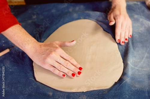 Master smoothes the layer of clay with your hands. The ceramist . Handmade