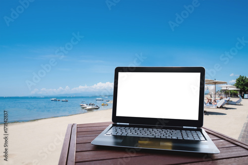 Laptop computer on wood table at the beach in summer © SasinParaksa