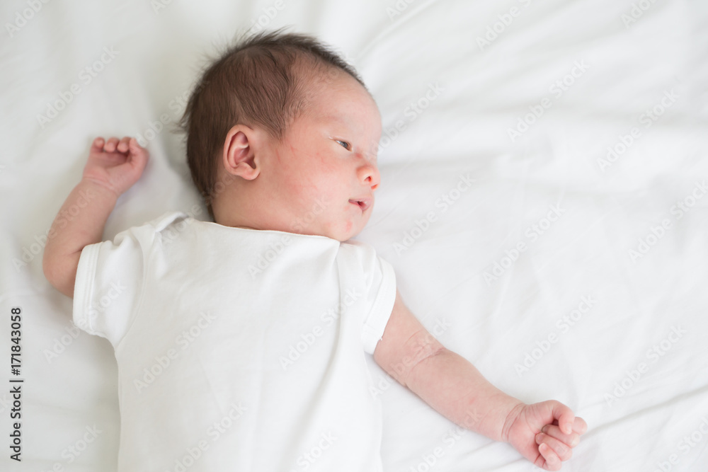 Asian newborn baby lying on the bed,Three week old Asian newborn baby lying on the bed,Three week old