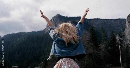 Success concept -Rural landscape. Fit woman with arms raised victoriously celebrating successful evening hike at beautiful sunset. Female model standing on top of the seaside mountain in worship pose photo