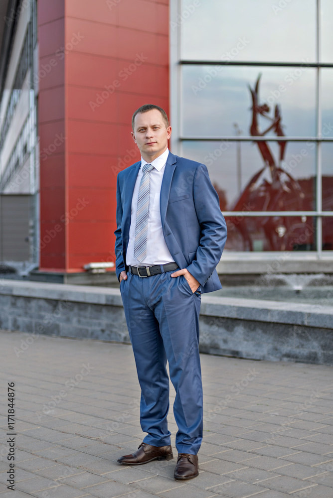 portrait of a young serious smiling businessman in grey blue suit portrait of a young serious smiling businessman in grey blue suit