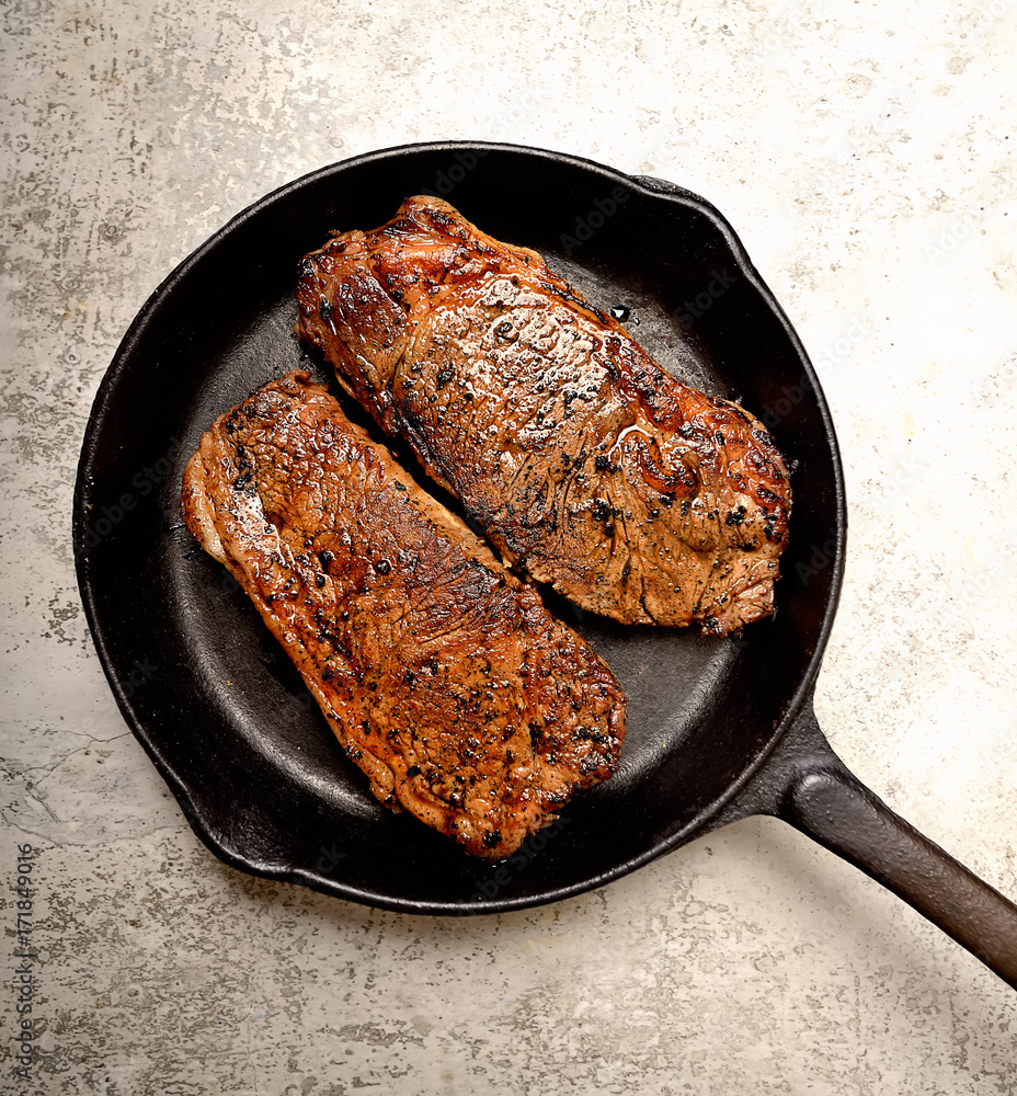 Fototapeta premium grilled steak and basil on a frying pan