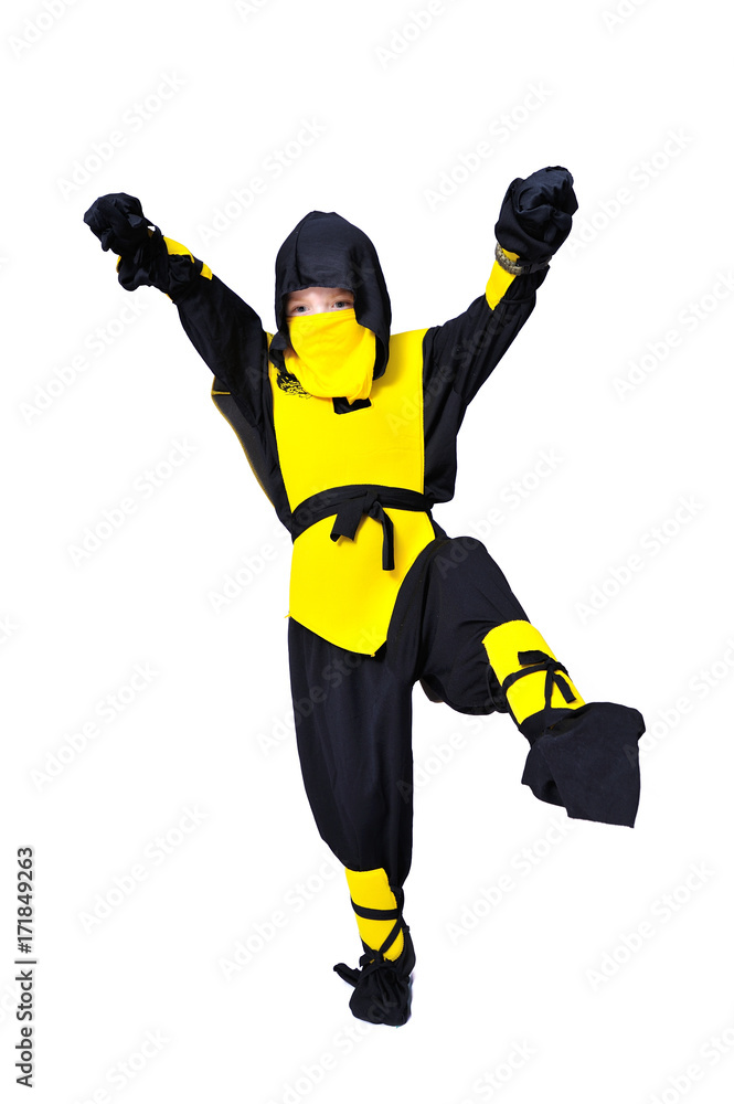 The seven-years old boy in black and yellow ninja suit with a hood and mask on his face bowed his head. With a knife in hand. Portrait in full growth The seven-years old boy in black and yellow ninja suit with a hood and mask on his face bowed his head. With a knife in hand. Portrait in full growth