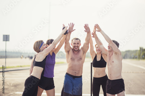 Fit people putting their hands together outdoor photo