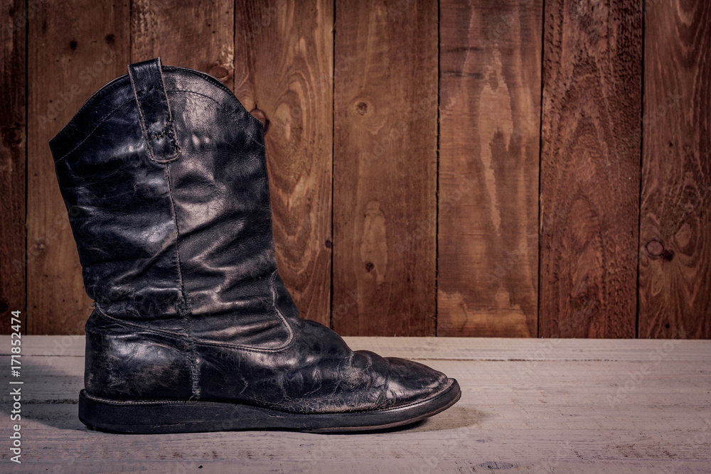 Old leather boots on dirt wooden background Old leather boots on dirt wooden background