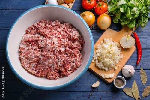 Bowl with ground turkey and ingredients for delicious meatloaf on wooden table