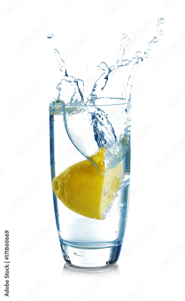 Falling sliced lemon into glass with water on white background