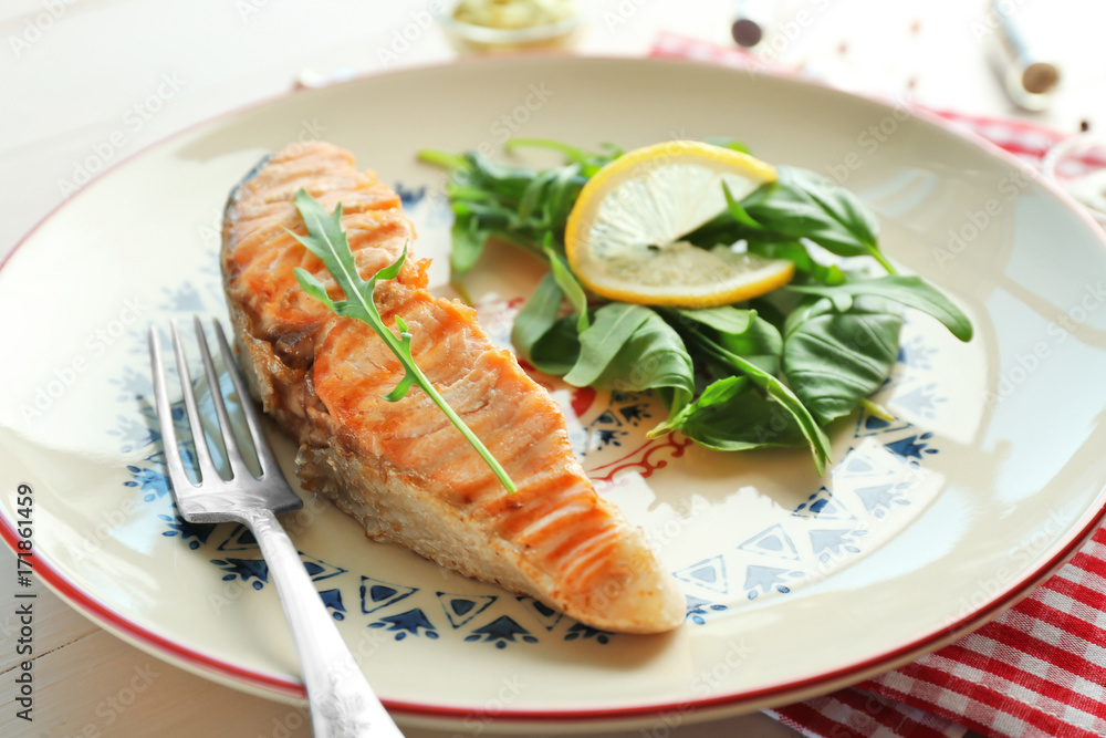 Plate with slice of salmon and herbs on table, closeup Plate with slice of salmon and herbs on table, closeup