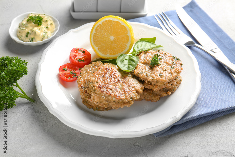 Delicious broccoli pancakes with sauce, lemon and fresh vegetables on grey background