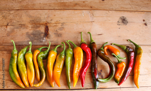 peperoncini piccanti di colore giallo,verde e rosso su sfondo di legno naturale photo