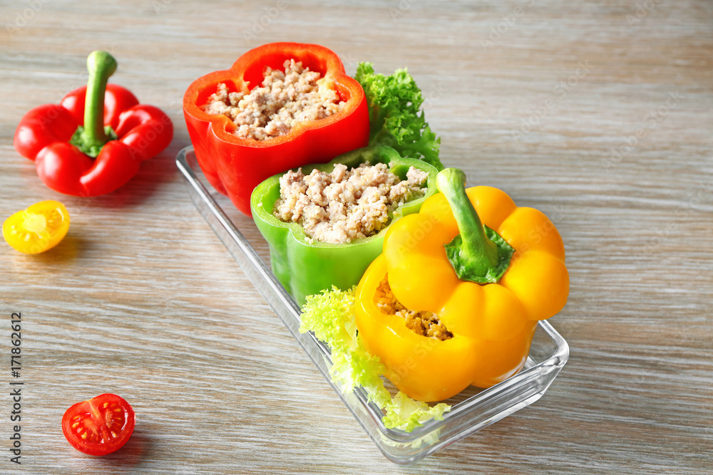 Quinoa stuffed peppers in baking dish on wooden background Quinoa stuffed peppers in baking dish on wooden background