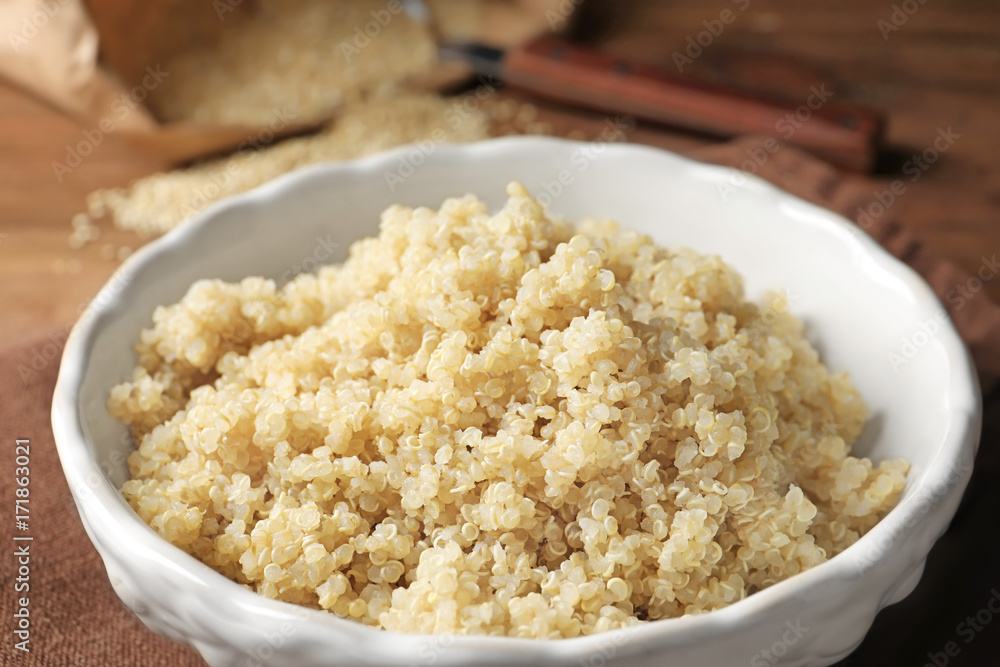 Bowl with boiled white quinoa grains on kitchen table Bowl with boiled white quinoa grains on kitchen table