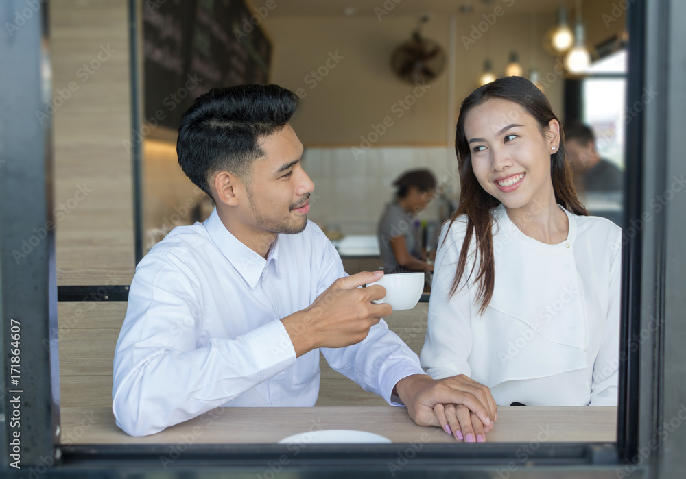 Obraz premium Asian young couple in love at a coffee shop