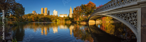 Fall in Central Park at The Lake with the Bow Bridge. Panoramic morning view with colorful autumn foliage on the Upper West Side. Manhattan, New York City