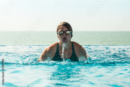 Woman in a swimming pool with ocean view
