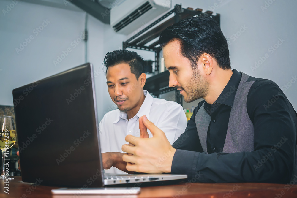 Two ethnic business people are discussing work for mutual success.Focus on the Caucasian man. Two ethnic business people are discussing work for mutual success.Focus on the Caucasian man.