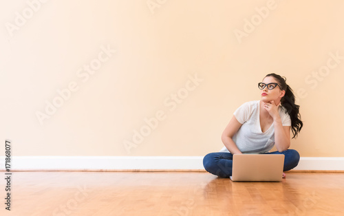 Young woman using her laptop in a big room