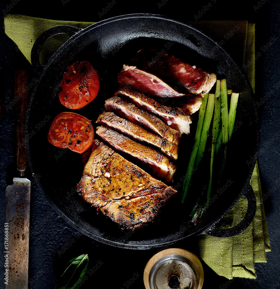 grilled steak and basil on a frying pan