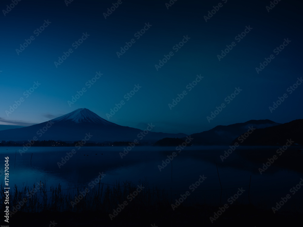 landscape view from sunrise and haze on kawaguchi lake with motion blur from group of duck foreground and fuji mountain background with fog from japan