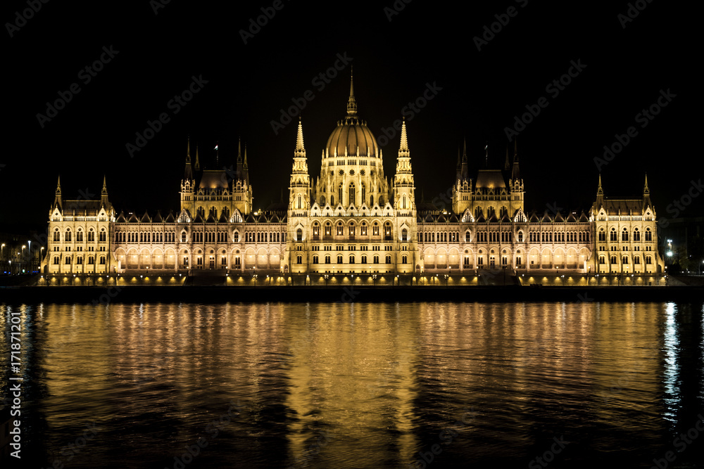 The Hungarian parliament is reflected in the water in budapest on the banks of the Danube.