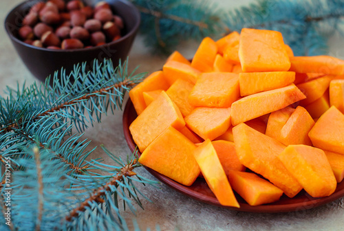 Sliced slices of pumpkin for a Christmas cake with spruce branches. photo