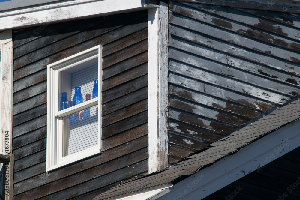 new england house with blue bottles in window new england house with blue bottles in window