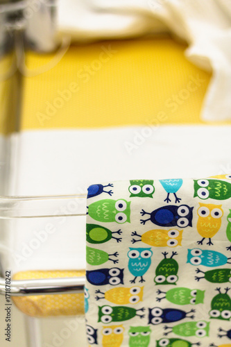 A colorful baby bed with a blanket at a maternity ward