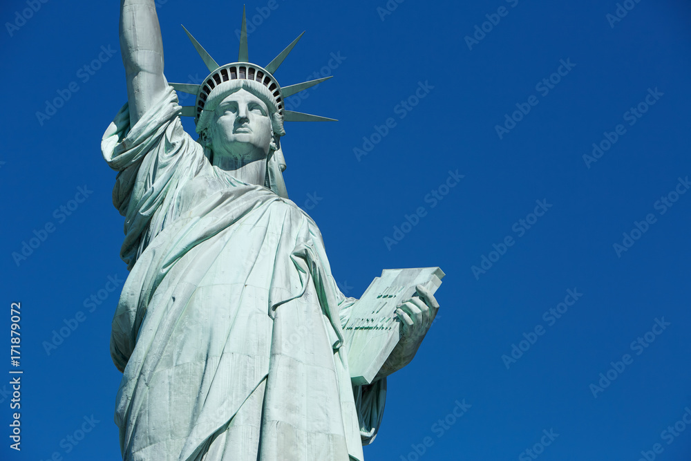 Fototapeta premium Statue of Liberty in a sunny day with blank blue sky space