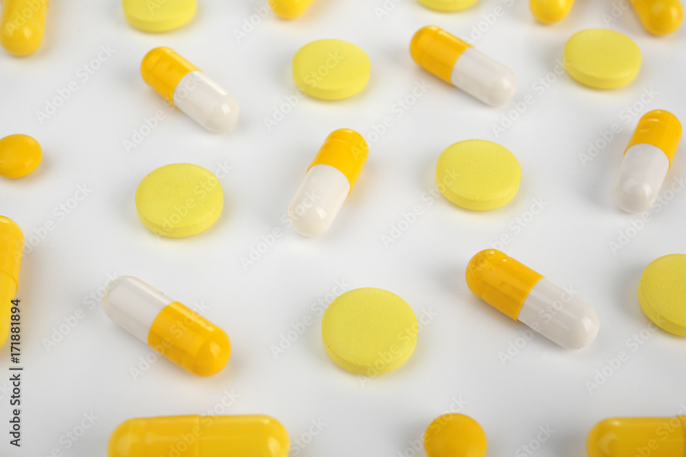 Different yellow pills on white background Different yellow pills on white background
