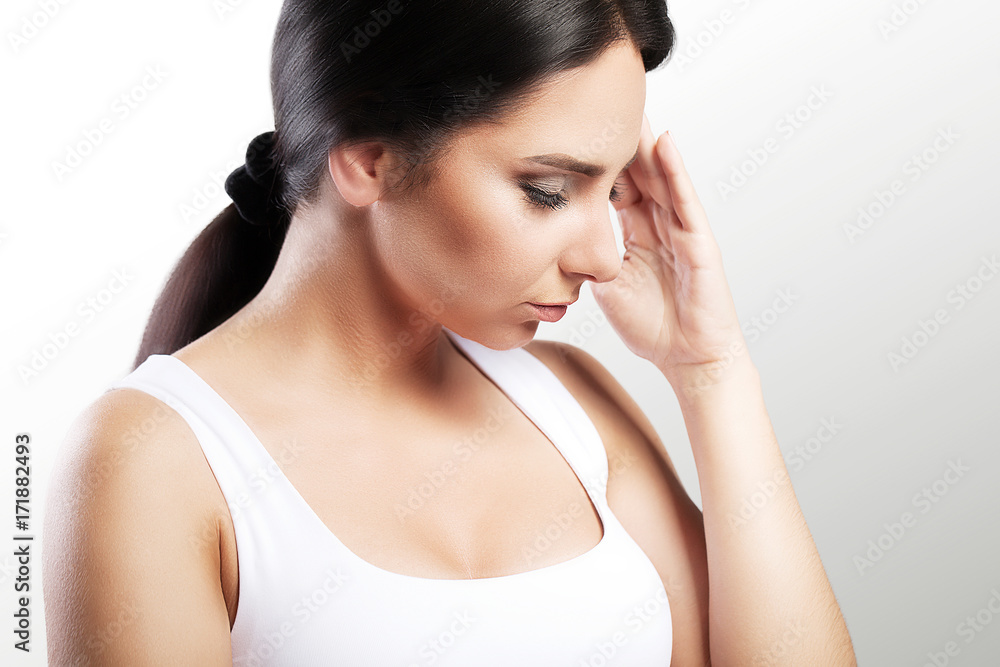 Young woman with headache, which holds her head, on a gray background, macrophotography, migraine, beautiful girl, professional makeup. Young woman with headache, which holds her head, on a gray background, macrophotography, migraine, beautiful girl, professional makeup.