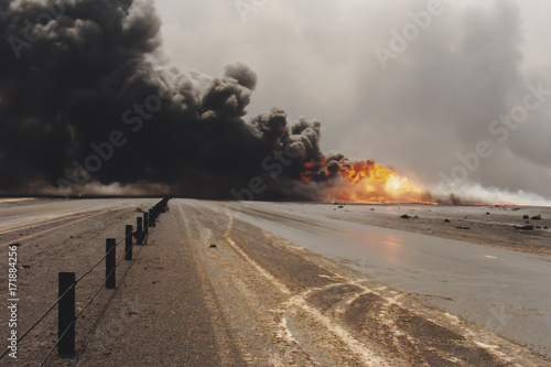 Obraz na plátne Road through oil well burning in field with oil slick, Kuwait