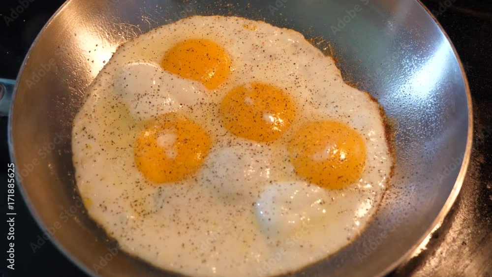 Applying pepper to some eggs with cooking Applying pepper to some eggs with cooking