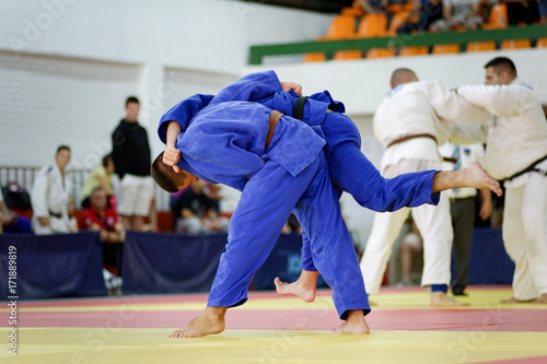 Two judokas in blue judo kimonos fighting