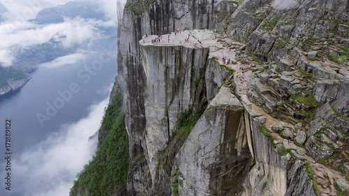 Helicopter shot amazing beautiful view of the cliffs. Tourists enjoy the scenery mountains in the fog and sea. Norway. Europe. Preikestolen Landscape, Prekestolen, Preacher's Pulpit or Pulpit Rock.