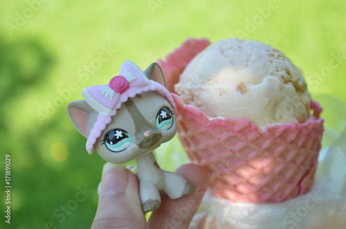 A toy cat with an ice-cream in the pink cone