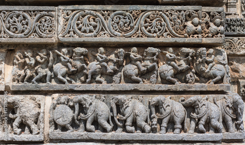 Mysore, India - October 27, 2013: Series of three friezes on outside wall of central shrine, called Trikuta, at Chennakesave temple in somanathpur. Warriors on horses, elephants, decorative.
