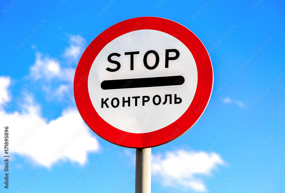 Traffic sign STOP on a blue sky background. Text in Russian: Traffic sign STOP on a blue sky background. Text in Russian: